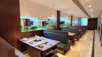 A restaurant with booths and tables, a large aquarium, and a modern interior design.