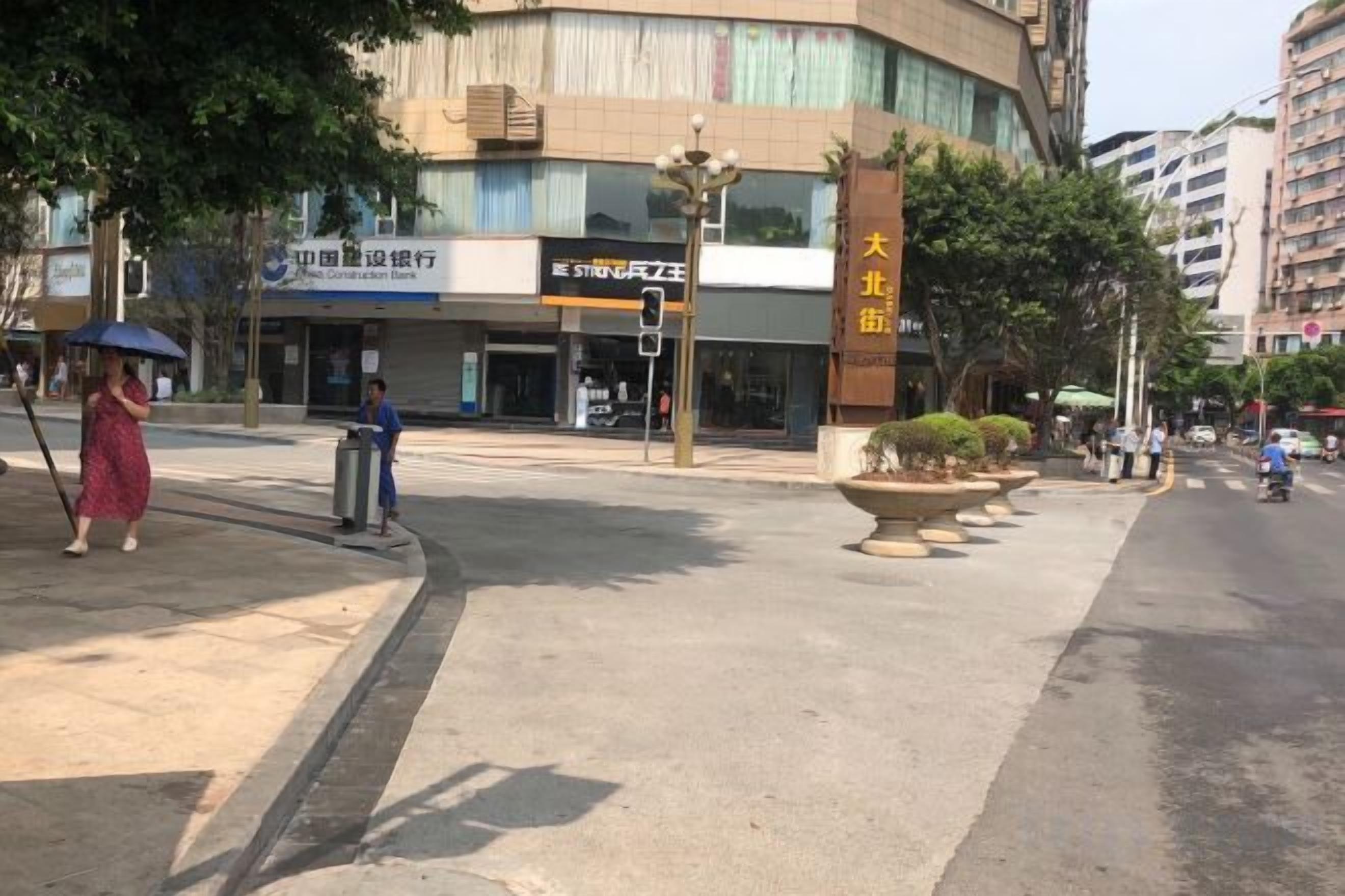 Una esquina de calle con un edificio que muestra un letrero de una clínica dental.