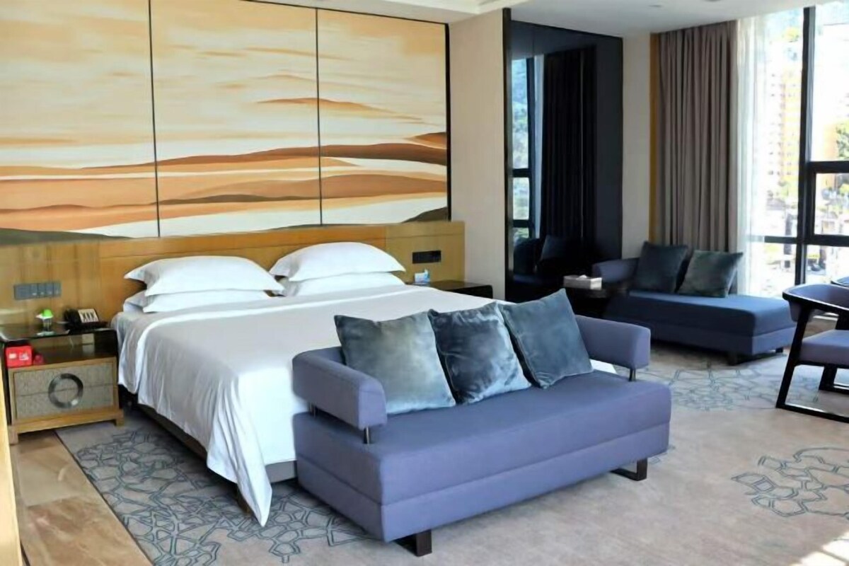 Ein modernes Hotelzimmer mit einem großen Bett, einer Couch und einem Schreibtisch.