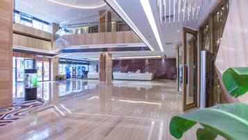 A spacious lobby with a high ceiling, multiple levels, and a modern design.