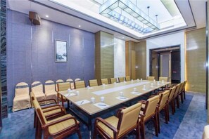 Une salle de conférence avec une longue table, des chaises et un plafond en verre.