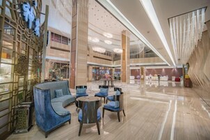 Um hall amplo com área de estar, teto alto e design moderno.