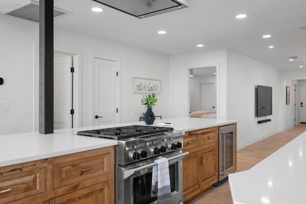 A modern kitchen with a central island, stainless steel appliances, and wooden cabinetry. - 7-acre, Sweeping Views, Hot Tub, Volley Ball, Close to Downtown! (Paso Robles)