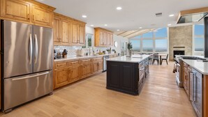 A modern kitchen with wooden cabinets, stainless steel appliances, and a large island.