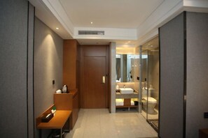 A modern bathroom with a glass shower enclosure, a wooden vanity, and a separate toilet area. - Mingzhu Hotel (Qingchuan)