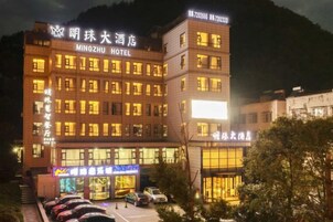 A multi-story hotel with illuminated signage and a parking lot.