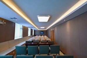 A hotel room with a long corridor, seating area, and a television screen. - Mingzhu Hotel (Qingchuan)