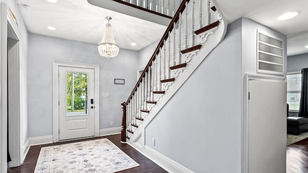 A staircase with white railings and dark wood steps leading to a landing.
