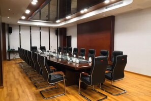 A conference room with a long table, multiple chairs, and a modern ceiling design. - Lian Shan Longshan Garden Hotel (Lianshan)