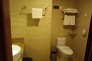 A bathroom with a toilet, a sink, a shower, and a towel rack. - Lian Shan Longshan Garden Hotel (Lianshan)