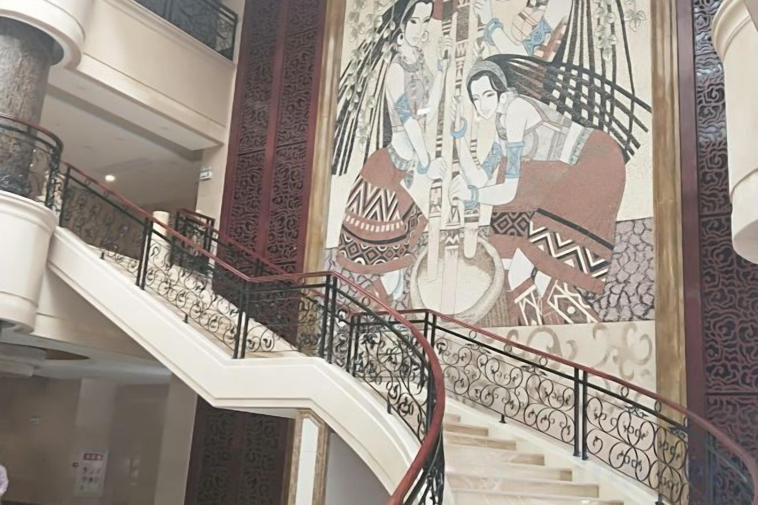 A multi-level interior with ornate railings and a large mural.