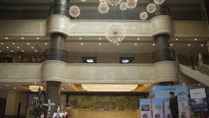 A spacious lobby with a grand chandelier, a reception desk, and a Christmas tree. - Lian Shan Longshan Garden Hotel (Lianshan)