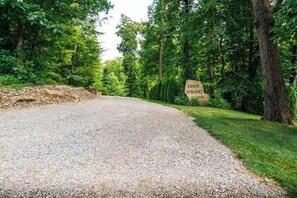 A gravel path leading through a wooded area with a sign indicating Fern Spring Cabin.