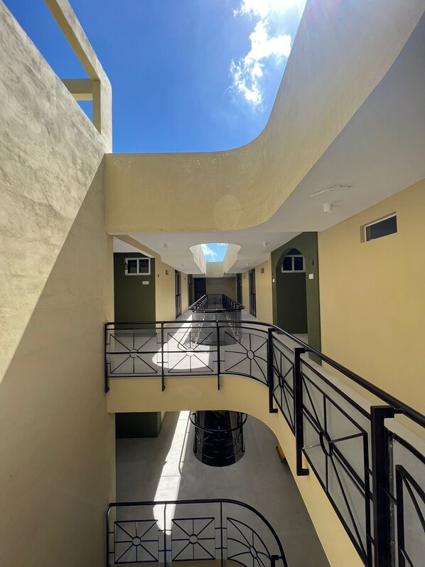 A multi-level interior with a central staircase, a skylight, and a curved ceiling. - LOL-HA Cancun Boutique Hotel (Cancun)