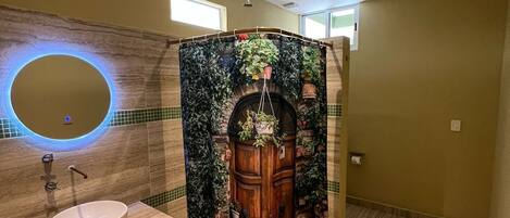 A bathroom with a wooden vanity, a round mirror, and a shower curtain with a door design.