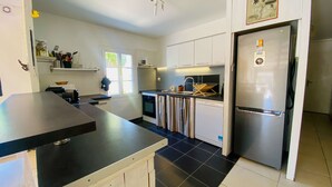 A modern kitchen with a black countertop, stainless steel appliances, and a large refrigerator. - Charming villa in a quiet location with courtyard (LE BOIS PLAGE EN RE)