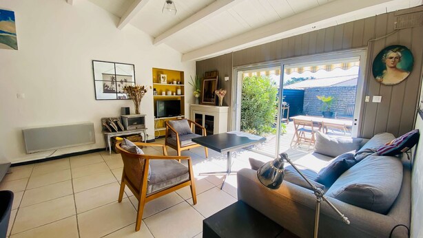 A living room with a sofa, chairs, a coffee table, a TV, and a fireplace. - Charming villa in a quiet location with courtyard (LE BOIS PLAGE EN RE)