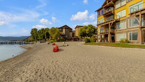 A beachside hotel with multiple floors, outdoor seating, and a view of the water.