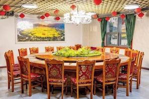 A dining room with a round table surrounded by chairs, a chandelier, and red lanterns. - Yajia Hotel (Kaiyang)