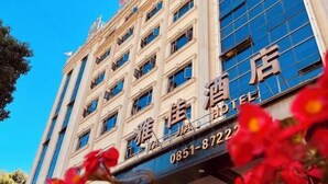 A hotel building with multiple floors, large windows, and a prominent sign with the name and contact number. - Yajia Hotel (Kaiyang)