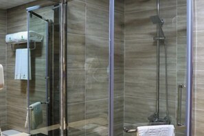 A modern bathroom with a glass shower enclosure, a towel rack, and a visible showerhead.