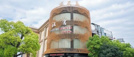 Ein Hotel mit einer geschwungenen Fassade, mehreren Etagen und einem markanten Eingang.
