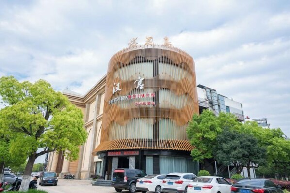 A hotel with a curved facade, multiple floors, and a prominent entrance.