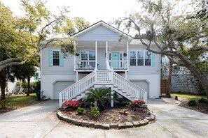 A two-story house with a front porch, a staircase, and a driveway. - Modern Boho style Folly beach house -3 blocks from the beach! (Folly Beach)