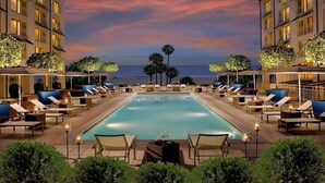 A poolside area with lounge chairs and a pool, overlooking the ocean. - La Plage Wellness (Santa Monica)