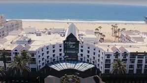 A hotel with a central courtyard, palm trees, and a beach view. - La Plage Wellness (Santa Monica)
