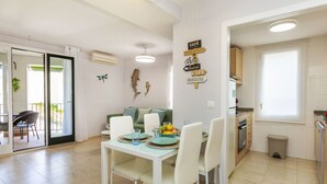A modern kitchen with a dining area, a built-in fridge, and a window. - Apartment Mitsu by Interhome (Tossa de Mar)