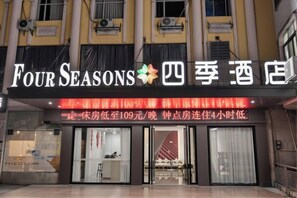 A hotel with a signboard displaying 'Four Seasons' and Chinese characters.