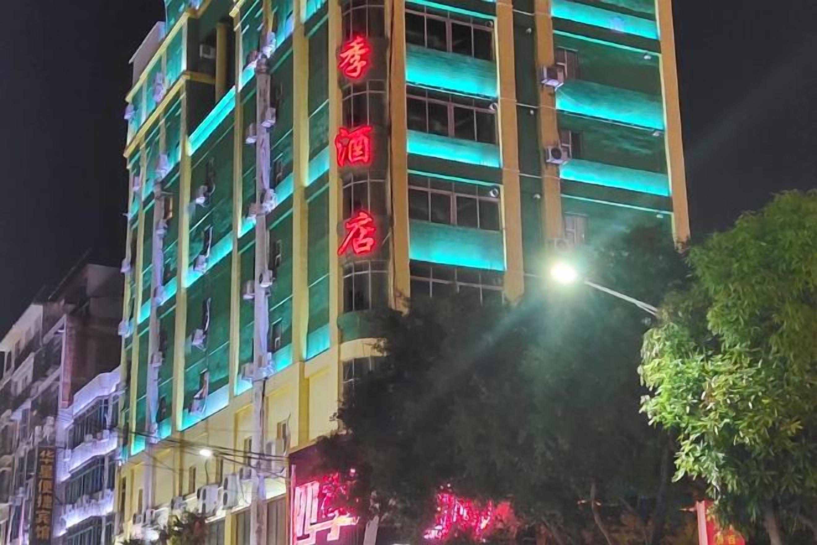 A multi-story building with illuminated signage indicating a hotel.