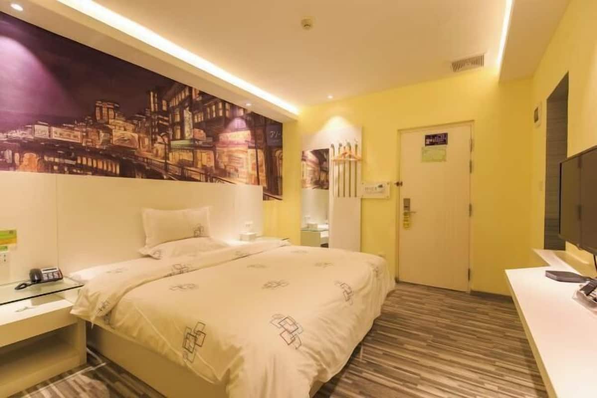 Quarto de hotel com duas camas, um grande mural com vista da cidade, uma televisão de tela plana e uma pequena mesa com telefone.