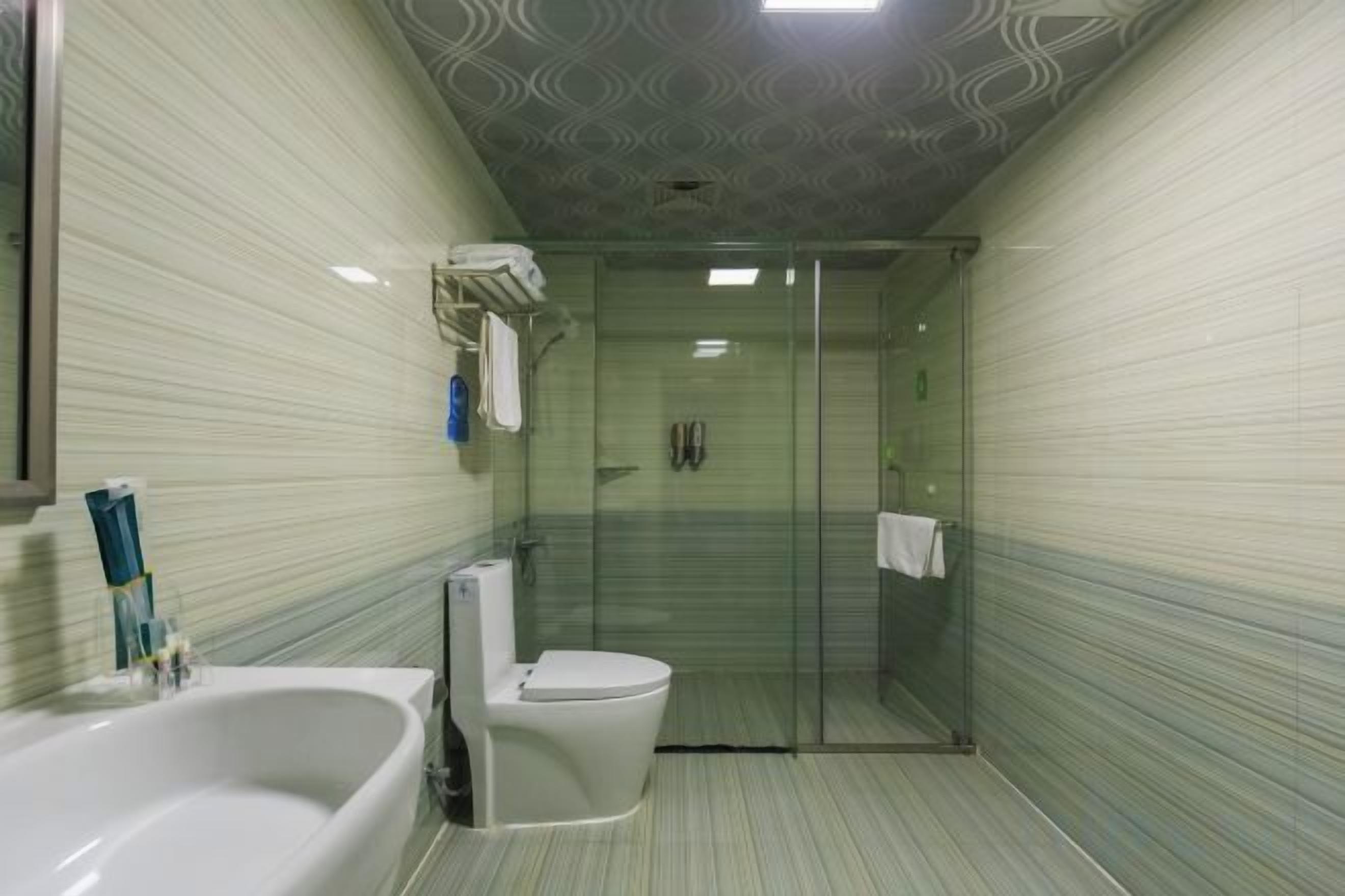 Un baño con ducha envuelta en vidrio, bañera y retrete.