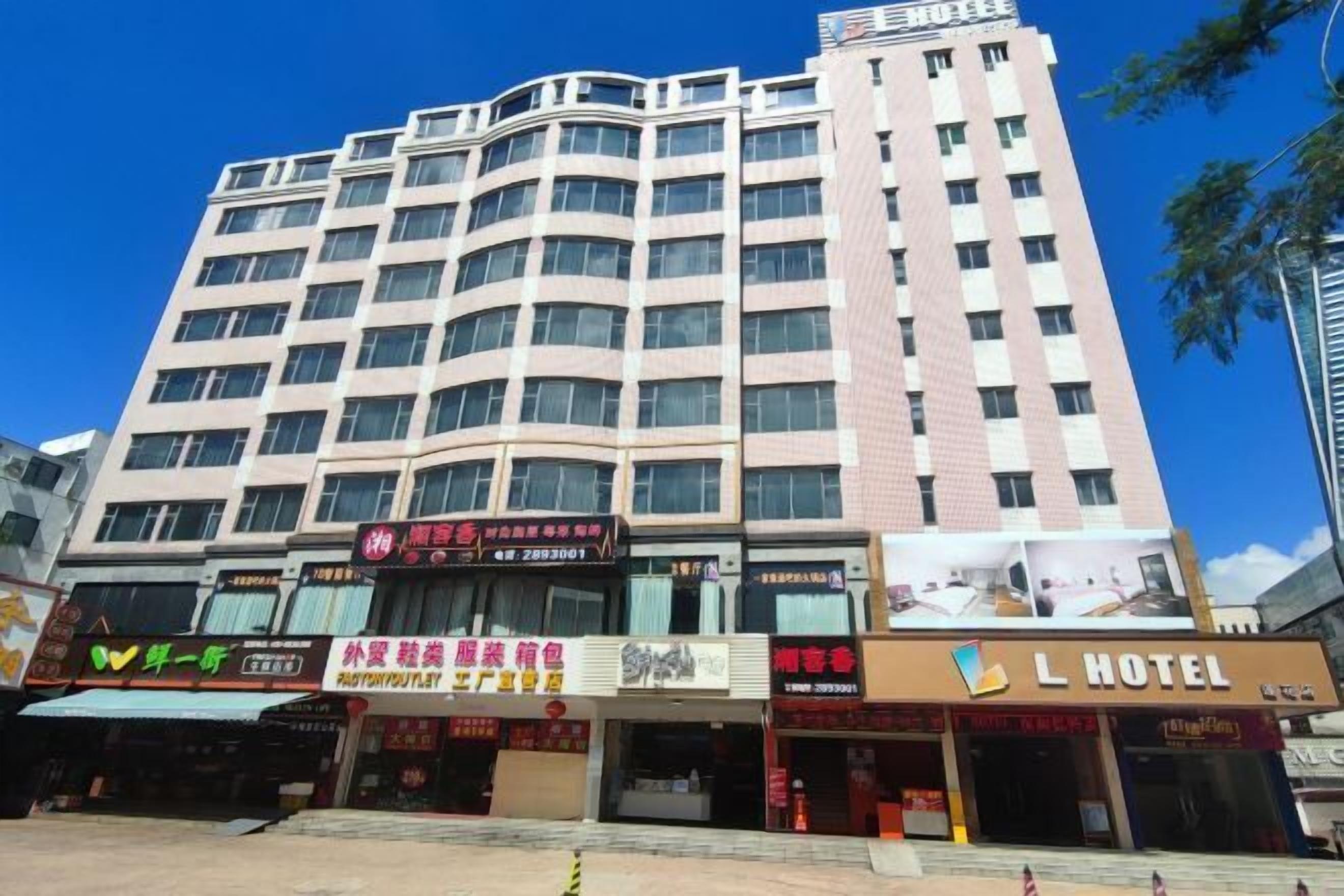 A multi-story hotel with a prominent L HOTEL sign on the facade.