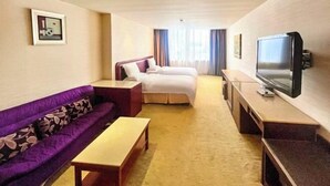 A hotel room with a sofa, a bed, a TV, and a desk. - L Hotel Zhuhai Gongbei Port Qinglv Road (Zhuhai)