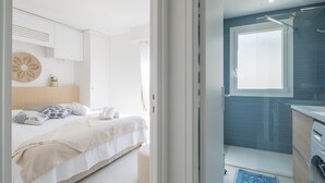 A modern bedroom with a bed, bedside table, and a wall-mounted decorative item. - Stylish 2-Br Apartment Steps from the Croisette (Cannes)