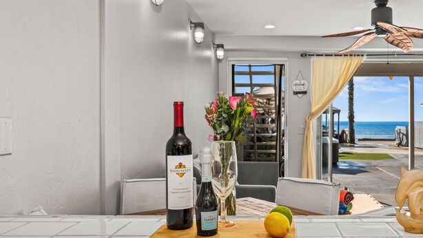 Una cocina con una botella de vino, una copa y un limón sobre tabla de cortar.