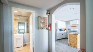 Una cocina moderna con armarios blancos, una isla de madera y un extintor de incendios en la pared.