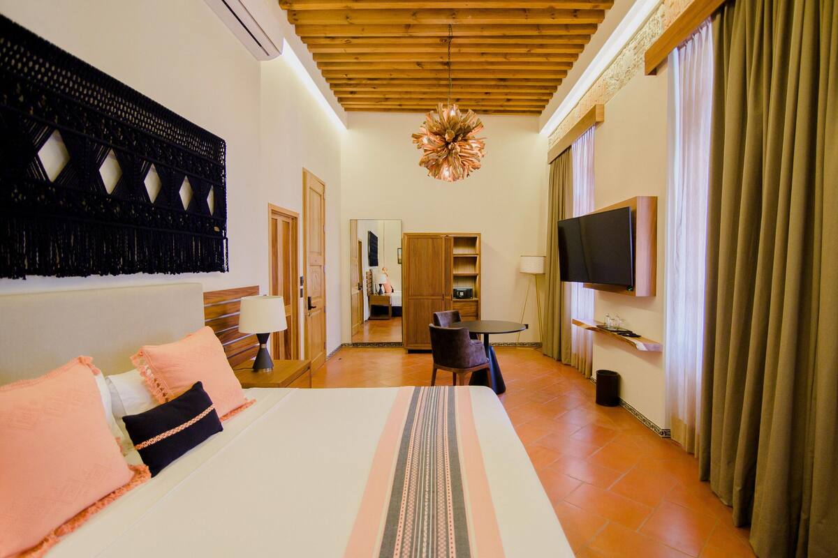 Une chambre d’hôtel équipée d’un lit, d’une télévision, d’un bureau et d’une chaise.