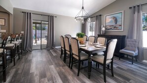 Un coin repas avec une table en bois, des chaises et un lustre.