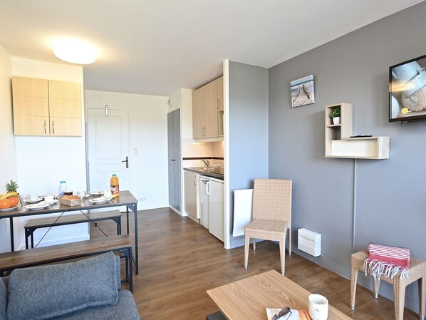 A compact living space with a dining area, kitchenette, and seating area.