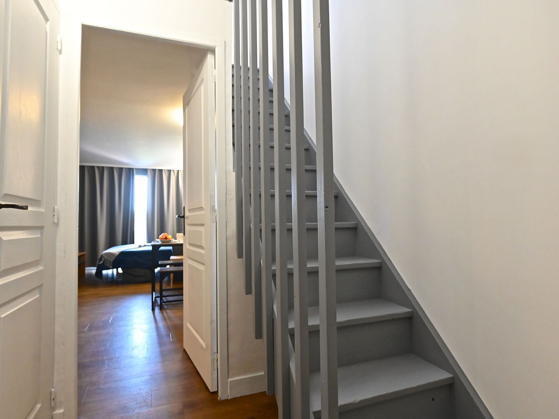 A hallway with a staircase leading to a landing.