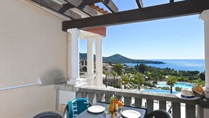 A balcony with a table set for dining, overlooking a pool and a mountainous landscape. - Cosy apartment for 6 people with WIFI, A/C, pool, TV, terrace and pets allowed (Saint-raphaël)