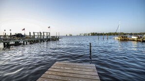 Un muelle de madera que se adentra en aguas tranquilas bajo un cielo despejado.