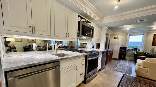 A modern kitchen with white cabinets, stainless steel appliances, and a large island. - 20 minute walk to downtown and beach - Rehoboth Ave Extended (Rehoboth Beach)