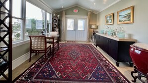 A spacious room with a high ceiling, a large window, a patterned rug, a dining area, and a kitchen counter. - 20 minute walk to downtown and beach - Rehoboth Ave Extended (Rehoboth Beach)
