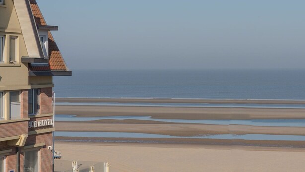 A hotel with a view of the beach and ocean. - Beautiful apartment for 4 people with WIFI, TV and pets allowed (De Haan)