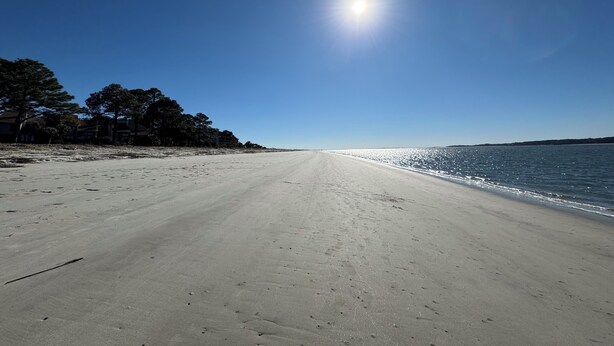 Ein Strand mit blauem Himmel und Sonnenschein.